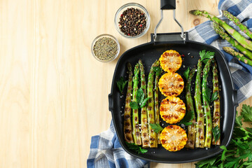 Delicious grilled vegetables with spices in pan on wooden table, flat lay. Space for text