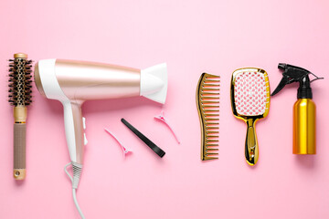 Different hair styling tools on pink background, flat lay