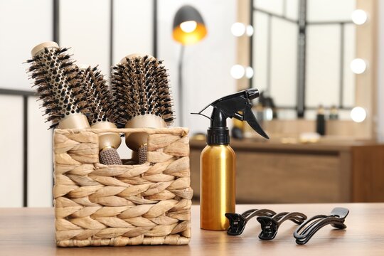 Different hair styling tools on wooden table in salon, closeup - Powered by Adobe