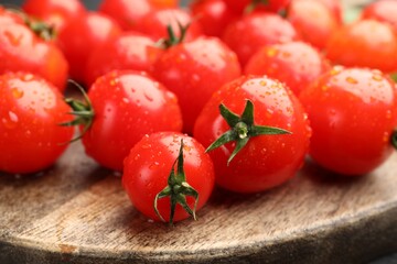 Fresh ripe tomatoes with water drops on table, closeup