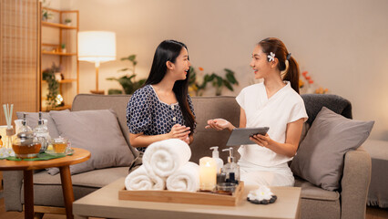 Asian adult women clients and therapist consult discussing spa wellness services options luxurious clinic for relaxation