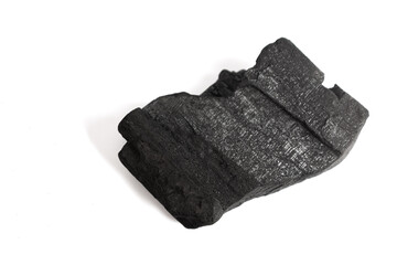 natural charcoal piece isolated on white background, showing rough porous texture and matte black surface, ideal for design projects about energy, fuel, art materials, or organic texture