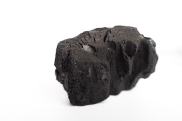 lump of natural black charcoal isolated on a bright white background, representing pure grilling fuel, carbon material, and energy source for cooking, heating, and environmental or raw material concep