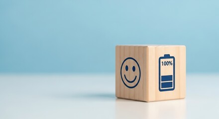 Mental Health in the work place, A wooden block featuring a smiley face and a battery icon, positivity and energy, set against a soft blue background.