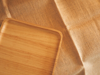 Wooden tray on burlap table for simple minimalist style background.