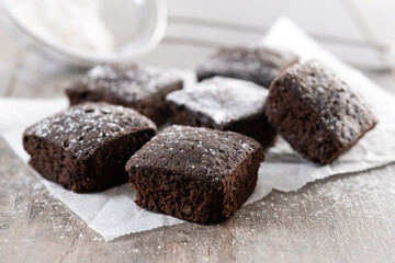 Homemade chocolate brownies with sugar powder on wooden table