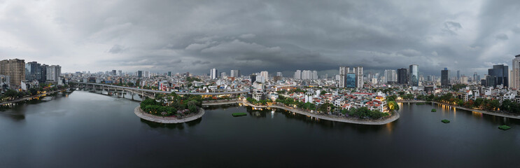 Panoramic aerial view of Hanoi city and Hoang Cau lake under dramatic storm clouds.