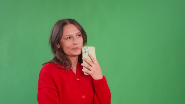 Enjoying a moment of self-reflection with a phone in front of a green backdrop