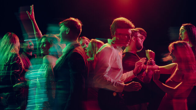 New Year party couple dancing with confetti in club smoke. Concept of holiday ads, alcohol launch promos, festive nightlife, and emotional connection