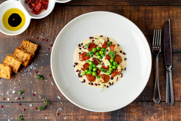Gnocchi served with peas and creamy sauce, plated elegantly