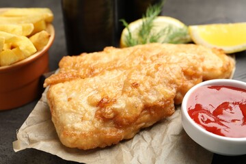 British Traditional Fish and chips served with sauce on grey table, closeup