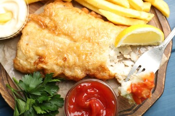 British Traditional Fish and chips served with sauces on blue wooden table, top view