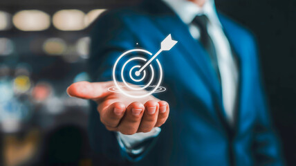 Businessman holding target icon with arrow success