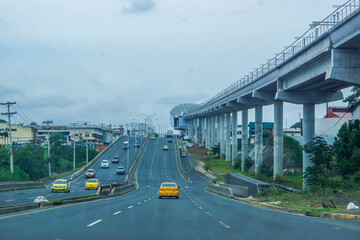 Urban highway in Panama City, Panama, with traffic, yellow taxis and modern transport...