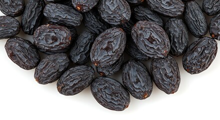 Close up of dried black raisins against a white background for food concepts