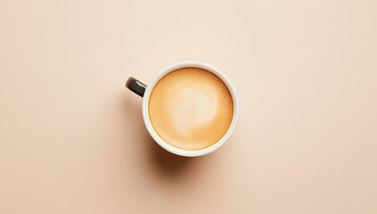 Overhead view of a creamy latte in a white mug with a dark handle