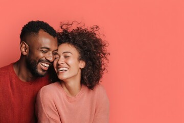 Obraz premium Interracial Couple Hugging and Laughing on Coral Background