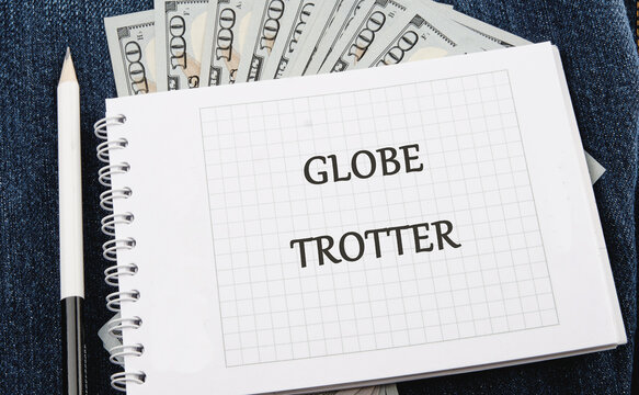 A notebook marked with the words globe trotter sits atop a stack of cash. This scene captures the spirit of travel and adventure, perfect for planning a journey