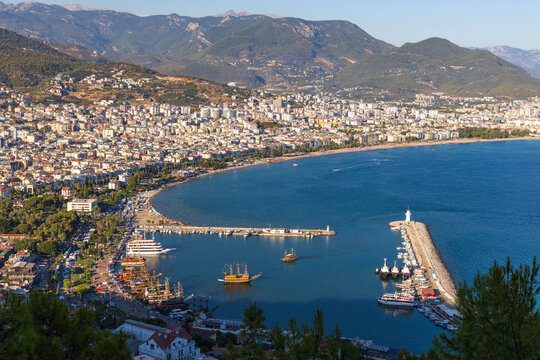 Vibrant seaside city along a blue bay featuring a busy harbor, marina, boats