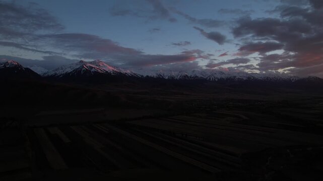 Majestic Sunset over Snow-Capped Mountains and Serene Fields Showcasing Natural Beauty in a Captivating Landscape
