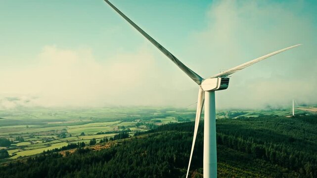 Aerial view of wind turbines among clouds on green hills in the irish countryside