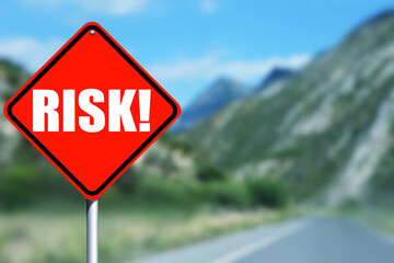 Red road sign with word Risk outdoors