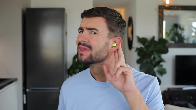 Stressed out man using ear plugs to stop the noise 
