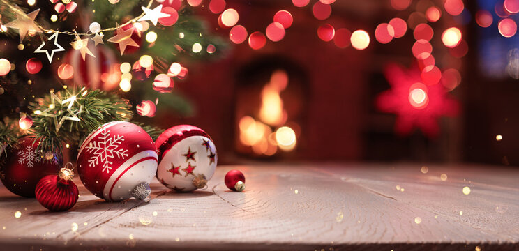 A Christmas Tree with Balls in the Foreground and Snowflake Symbols. Fireplace. Red Lights and a Bright Garland with Stars. Light Wooden Background