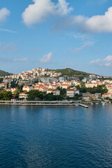 Fototapeta premium Vertical view of a picturesque coastal town in Dubrovnik, Croatia, with traditional architecture on a green hill next to the blue Adriatic Sea.