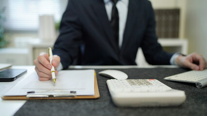 businessman hand working with finances about cost and calculator and computer on desk in modern office