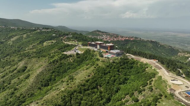 Sighnaghi, Georgia - July 15 2025: Aerial view of modern hilltop hotel Bodbe. Complex with Pool Terrace Overlooking Lush Green Valleys and Distant Horizon over Sighnaghi city