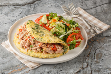 Full breakfast Omelet with tuna and pepper served with vegetable salad close-up in a plate on the...