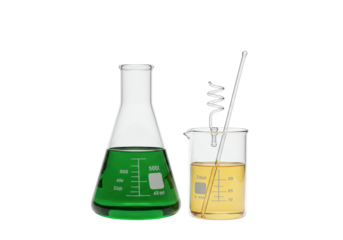 Isolated Erlenmeyer flask with green liquid next to beaker and glass distillation device