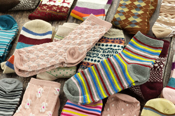 Many different socks folded on a wooden background. Close-up. Colorful socks for fall and winter.
