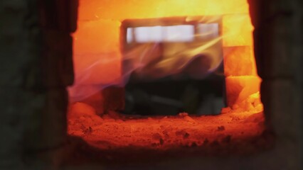 Hot metal glowing inside brick furnace. Stock clip