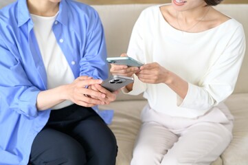A Japanese woman sitting on the sofa holding her smartphone