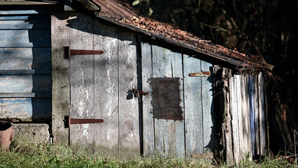 Ukrainian village house, surrounded by trees in the garden and greenery. A glimpse into traditional rural life and folk architecture. A house in a village, a summer cottage, close-up