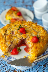 Piece of strawberry pie with lemon and fresh berries on lace light blue tablecloth