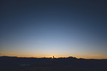 Hiker Silhouette Watching Sunrise from Isthmus Peak, Wanaka, New Zealand