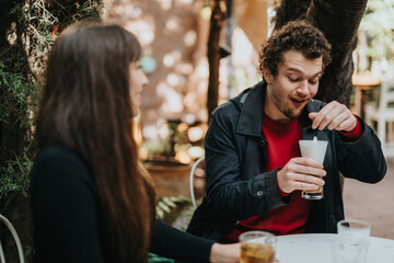 Two individuals having a cheerful conversation outdoors with beverages, showcasing friendship and happiness.