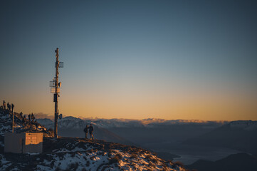 Hiker Watching Sunrise Over Lake Wanaka from Roys Peak Summit, New Zealand