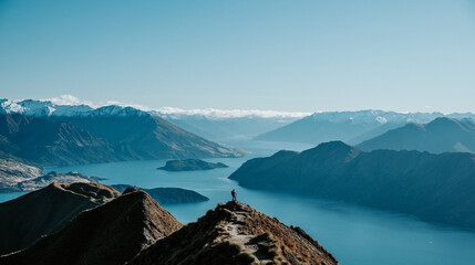 Hiker Standing on Roys Peak Viewpoint Overlooking Lake Wanaka and Southern Alps, New Zealand