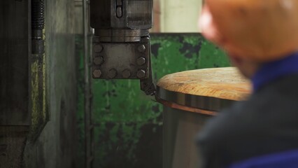 Industrial machine cutting metal edge with worker supervising. Stock clip