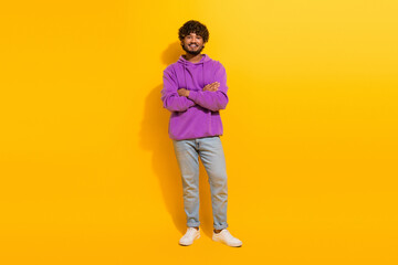Young man in purple hoodie smiling confidently on a vibrant yellow background, embodying modern...