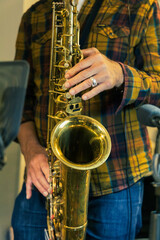 Obraz premium A man playing saxophone in a recording studio, surrounded by microphones and sound equipment.