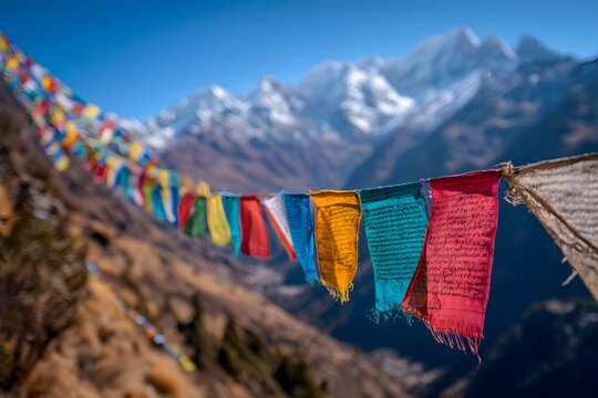 Colorful Himalayan prayer flags wave in a travel landscape below snowy mountains.