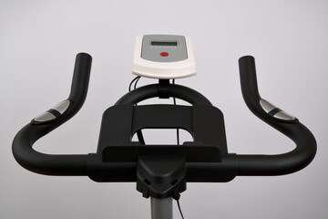 Macro full frame photography of black spin bike handlebars against white background