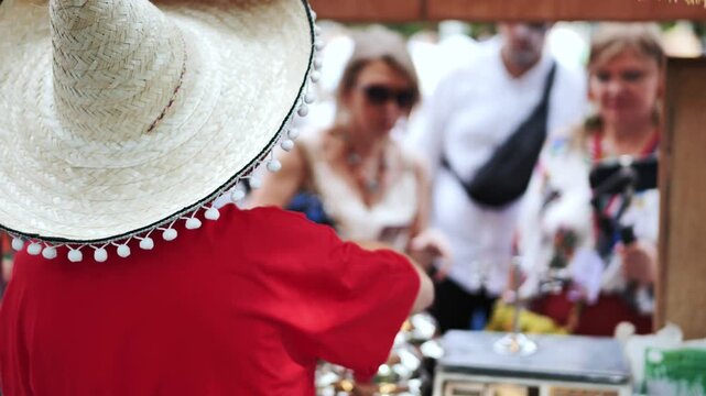 Street vendor wearing sombrero working at a traditional mexican food stall