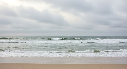 Ocean view under cloudy sky with waves meeting the sandy shore