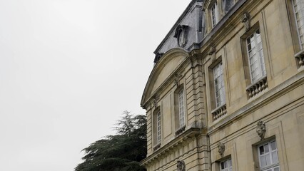 Majestic stone mansion with mansard roof and ornate details. Action